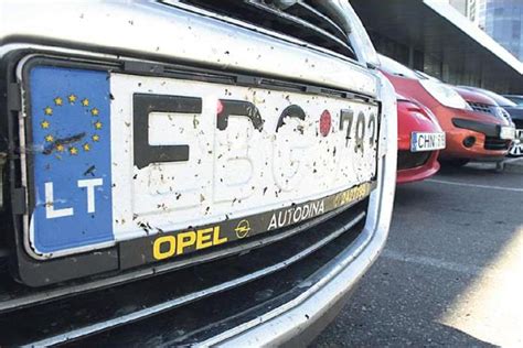 Tematinė nuotrauka, vaizduojanti nusilupusį automobilio numerio ženklą su E raide