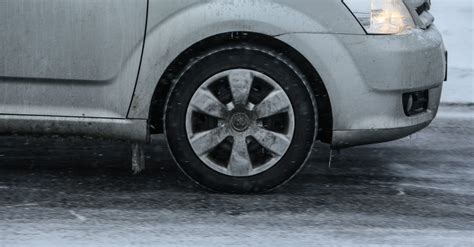 Teminė nuotrauka su automobilio padangomis ant apsnigto kelio