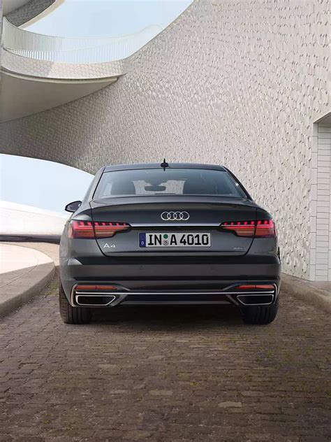 The Audi A4 sedan driving on a scenic road, highlighting its sleek design and elegant lines.