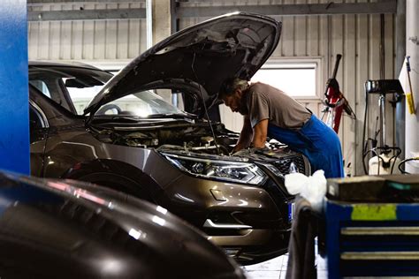 Serviso darbuotojas remontuoja automobilio priekabą