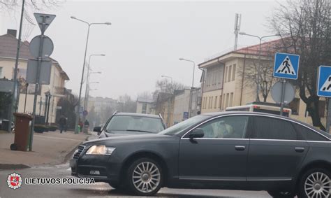 Teminis mažojo automobilio paveikslėlis su jaunuoliu prie vairo mieste