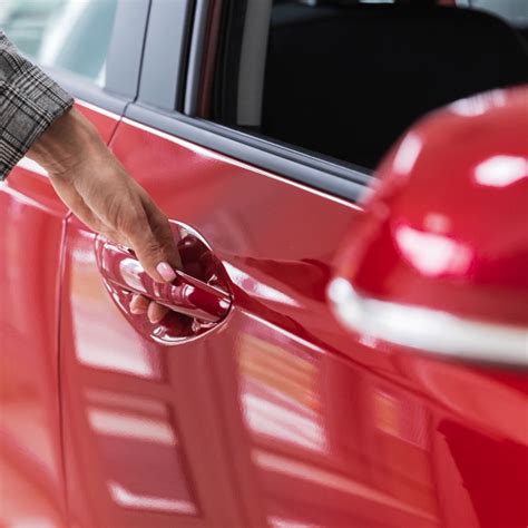 Nuotrauka, vaizduojanti asmenį, bandantį atrakinti automobilį telefonu