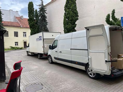 Teminė nuotrauka su perkraustymo darbuotojais kraunančiais baldus į sunkvežimį