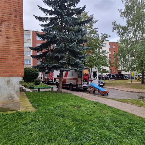 Žmonės plauna automobilius prie daugiabučio
