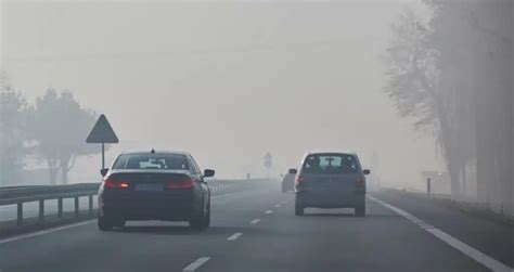 Teminė nuotrauka su automobiliu rūke ir įjungtais rūko žibintais