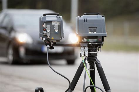 Policijos pareigūnas prie mobiliojo greičio matuoklio