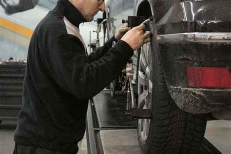 Tematinė nuotrauka: meistras atlieka antikorozinį padengimą pakeltam automobiliui