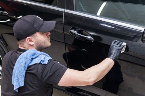 Teminė nuotrauka: autoserviso darbuotojas remontuoja automobilį su apsauginėmis priemonėmis