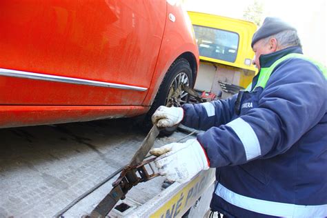 Asmuo keičia pradurtą automobilio padangą šalikelėje