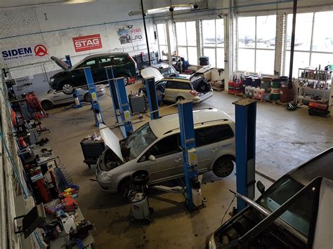 nuotrauka su automobilių serviso mechaniku, atliekančiu vairo sistemos diagnostiką