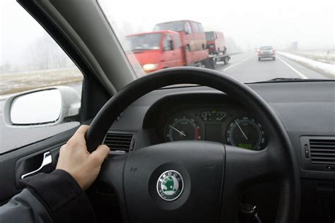 Vairuotojo rankos ant vairo, simbolizuojančios automobilio valdymą
