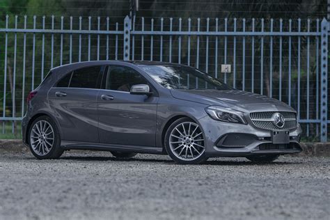 Nuotrauka, vaizduojanti Mercedes-Benz A180 trečios kartos modelio priekį, pabrėžiant jo dinamišką ir modernią išvaizdą.