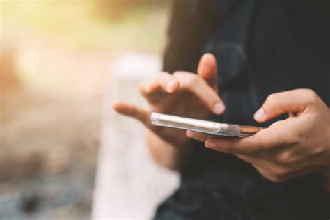 Tematinė iliustracija su išmaniuoju telefonu ir procentais išsikraunančia baterija