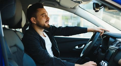 Teminė nuotrauka: žmogus prie automobilio vairo, besiruošiantis važiuoti