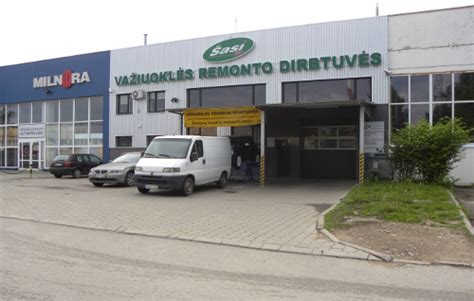 Nuotrauka, vaizduojanti autoserviso meistrą, atliekantį važiuoklės diagnostiką
