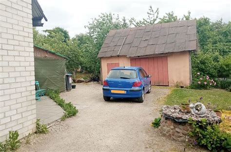 Teminė nuotrauka su žmogumi, plaunančiu automobilį namų kieme