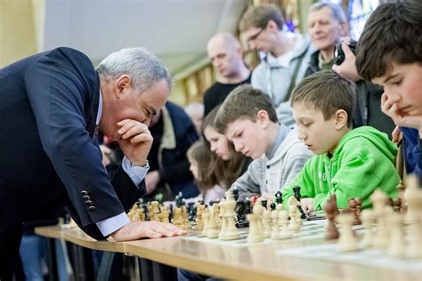 vaikai žaidžia šachmatais prie didelės lauko šachmatų lentos