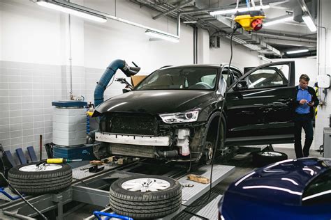 Teminė nuotrauka: autoserviso darbuotojas remontuoja automobilio bagažinę