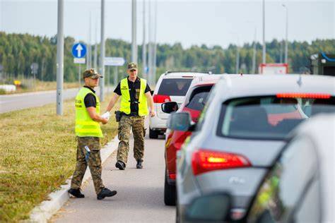 Laiškininkas su automobiliu prie pašto skyriaus