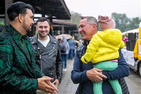 Nuotrauka, vaizduojanti festivalio dalyvius, einančius per purvą po liūties.