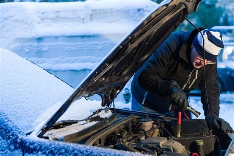 Tematinė nuotrauka: žmogus keičia automobilio akumuliatorių žiemą