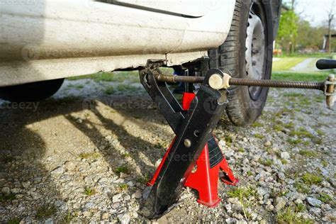 Car on a jack with a flat tire being changed