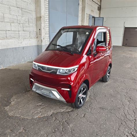 Elektrinis keturratis mini automobilis važiuojantis miesto gatve