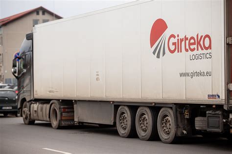 Motyvuojanti nuotrauka su Girteka sunkvežimiu ir laimingu vairuotoju
