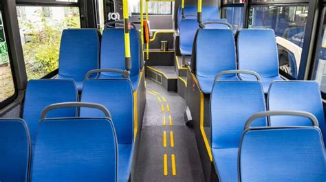 Teminis autobuso interjero vaizdas su keleiviais ir atlaisvinta vieta neįgaliesiems/vaikams su vežimėliais