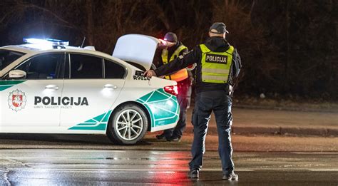 Teminė nuotrauka, iliustruojanti neblaivaus vairuotojo problemą: policijos pareigūnai stabdo automobilį