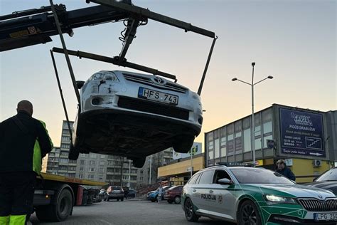 Žmonės apžiūrinėja automobilius didelėje pardavimo aikštelėje
