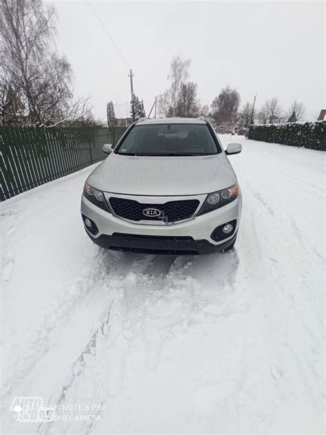 Teminė nuotrauka su Kia Sorento 2009 m. modeliu ir guminiais kilimėliais