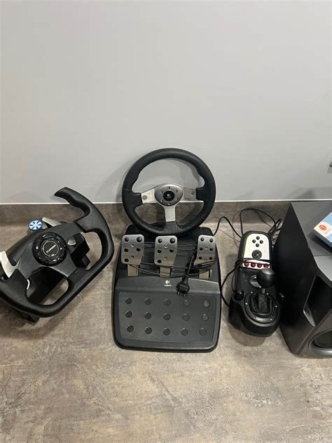 Nuotrauka su Logitech G923 vairu ir pedalais, demonstruojanti metalinę pedalų sistemą.