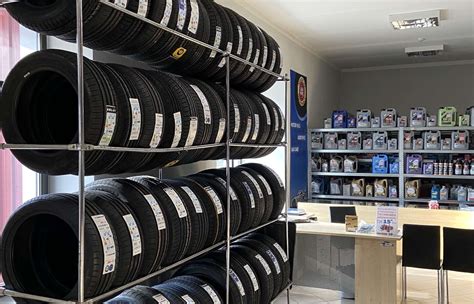 nuotrauka su įvairių automobilių padangų ir akumuliatorių ekspozicija autoservise