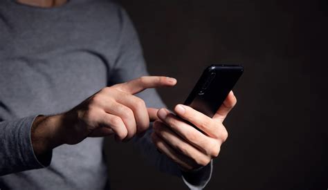 Tematinė nuotrauka: žmogus naršo internete išmaniajame telefone, ieškodamas greitojo kredito