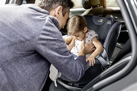 Tėvai įrengia vaikišką kėdutę automobilyje