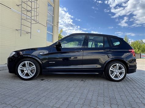 BMW X3 su R19 ratlankiais, važiuojantis keliu