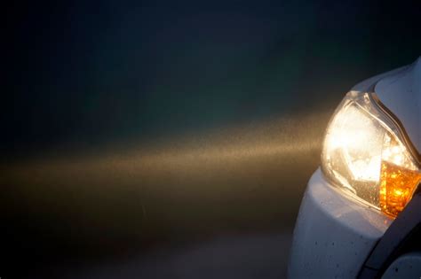 Teminė nuotrauka su automobilio priekiniais žibintais naktį