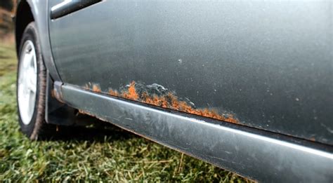 rūdžių pažeisto automobilio kėbulo fragmentas