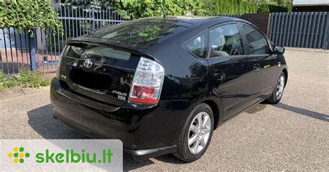 Toyota Prius automobilio kapotas atidarytas, matomas 12V akumuliatorius ir hibridinės sistemos komponentai