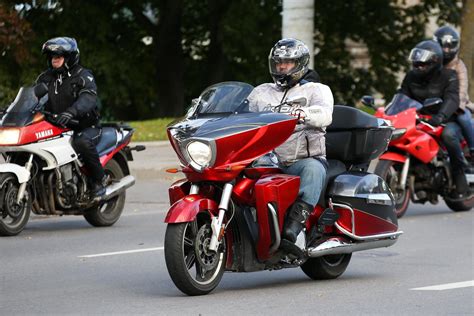 motociklininkas važiuoja tarp automobilių spūstyje