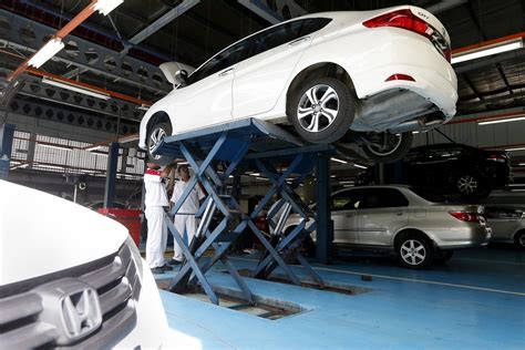 Tematinė nuotrauka, vaizduojanti autoservisą arba mechanikus, dirbančius su automobiliu