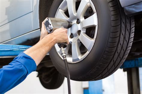 Teminė nuotrauka: autoserviso darbuotojas keičia padangas